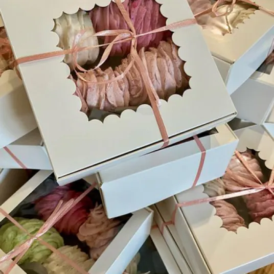 Stack of white gift boxes with scalloped windows