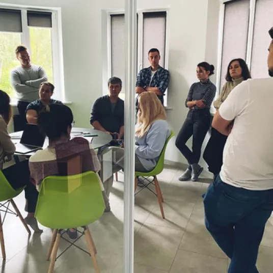A group of about 10 people in a modern office meeting room