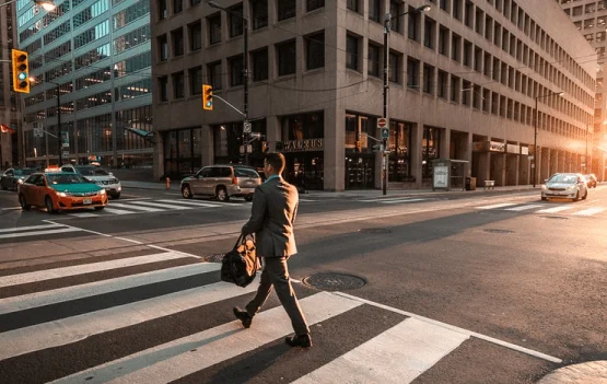 A professional walking across a zebra crossing