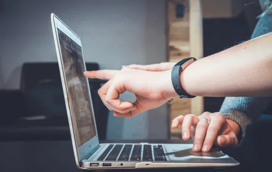 A collaborative work scene with two people working together on a laptop