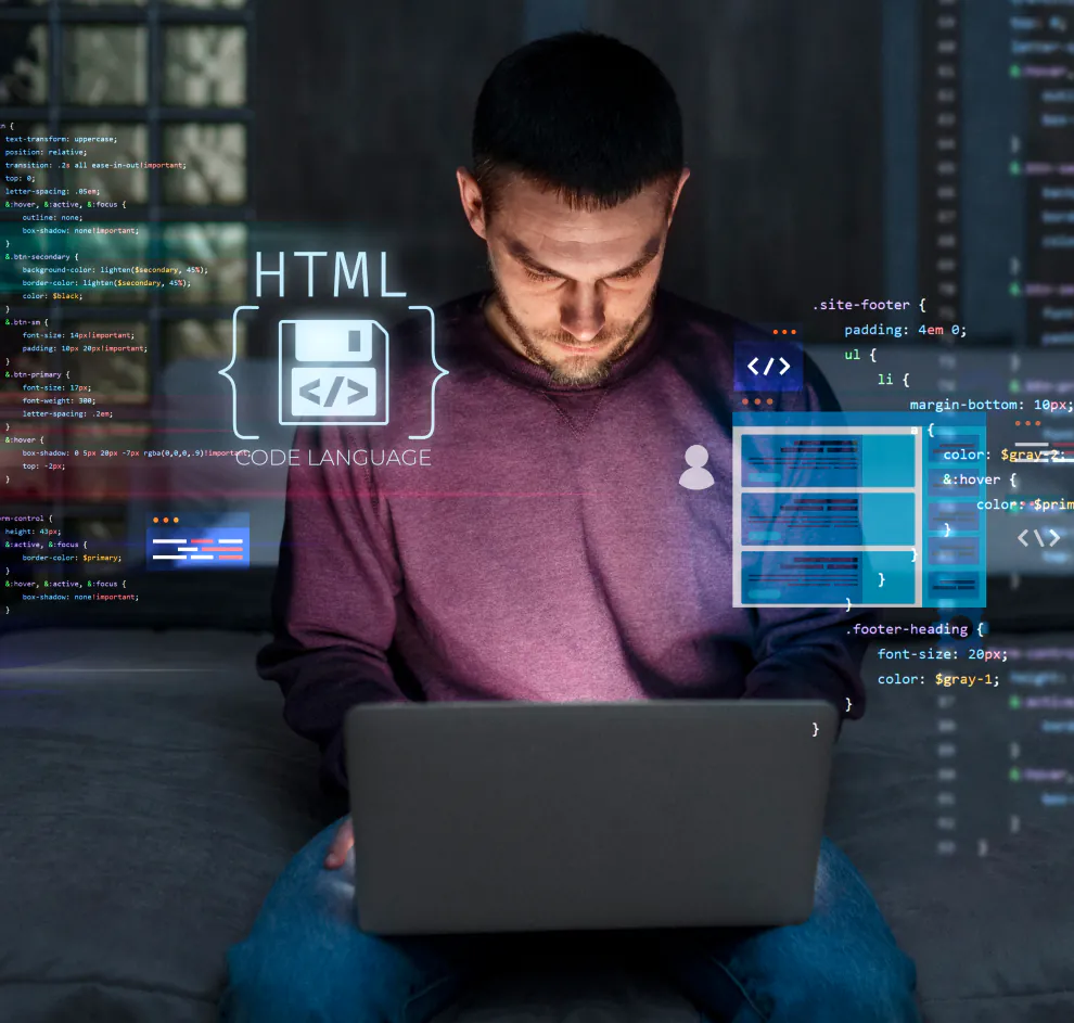 Man coding on laptop with glowing holographic HTML code overlays in dark room